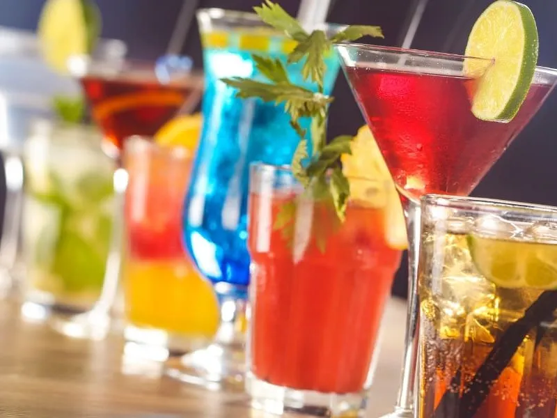 Elegante Cocktailbar mit bunten Drinks und Garnituren am Abend Elegante Cocktailbar mit bunten Drinks und Garnituren am Abend